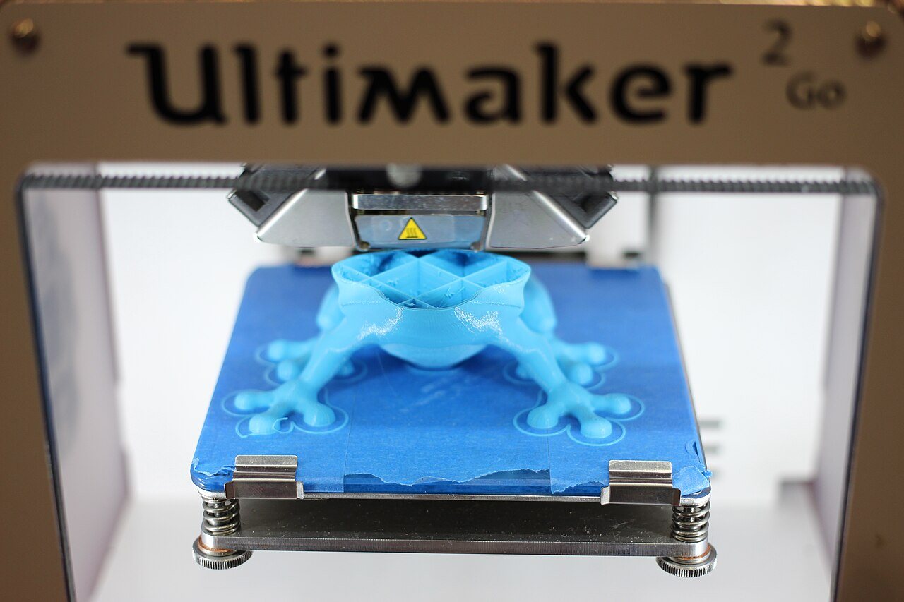 A 3D printer laying down layers of filament onto a glass build plate